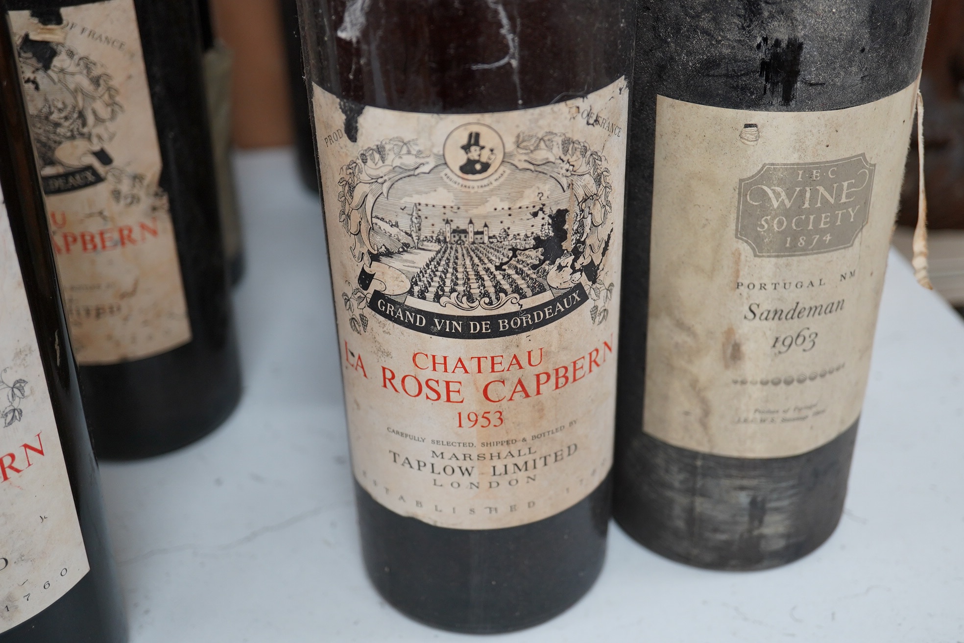 Fifteen bottles of wine and fortified wine, including; a Sandeman 1963 port, four bottles of Chateau La Rose Capbern 1953, a 1976 Madiran Cuvee de la Confrerie, etc. Condition - poor to fair, storage history unknown